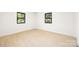 Well-lit bedroom with light wood floors and two windows offering natural light at 3801 Woodleaf Rd, Charlotte, NC 28205