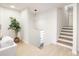 Welcoming entryway with a modern light fixture, stairs, and light wood flooring at 3801 Woodleaf Rd, Charlotte, NC 28205