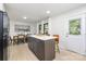 Bright kitchen featuring a dining area, white cabinets, island seating and door to backyard at 3801 Woodleaf Rd, Charlotte, NC 28205