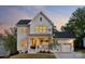 Attractive two-story home with a welcoming front porch and a convenient three-car garage at dusk at 4012 Spring Cove Way, Belmont, NC 28012