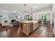 Open-concept kitchen island featuring a farmhouse sink, stainless steel appliances, and pendant lighting at 4012 Spring Cove Way, Belmont, NC 28012