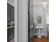 Hallway view into powder room with modern pedestal sink and designer mirror at 4109 Arbor Spring Ct, Belmont, NC 28012