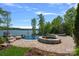 Beautiful infinity pool and spa overlooking the lake with lush greenery, creating a private oasis at 4109 Arbor Spring Ct, Belmont, NC 28012
