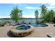 Stunning infinity pool with lake views, surrounded by lush landscaping, offering a luxurious outdoor experience at 4109 Arbor Spring Ct, Belmont, NC 28012
