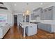 Modern kitchen with a large island, gray cabinets, stainless steel appliances, and hardwood floors at 4109 Arbor Spring Ct, Belmont, NC 28012