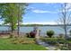 Serene lakeside property featuring a manicured lawn, a boat dock, lush greenery, and a black aluminum fence at 4109 Arbor Spring Ct, Belmont, NC 28012