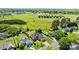 Serene aerial view showcasing a home with a pool, bordering green fields and sunny skies at 4705 Granite Ct, Indian Trail, NC 28079