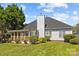 View of the home's back exterior with a screened-in porch, gray siding, and lush landscaping at 4705 Granite Ct, Indian Trail, NC 28079