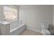 Bright bathroom with a white soaking tub, tiled walls, and natural light from the window at 4705 Granite Ct, Indian Trail, NC 28079
