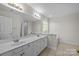 Bright bathroom featuring double sink vanity, neutral tile floor, tub and large mirror at 4705 Granite Ct, Indian Trail, NC 28079