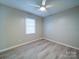 This bedroom features wood-look flooring, a ceiling fan, window, and neutral wall color at 4903 Walt Gay Rd, Monroe, NC 28112