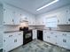 Updated kitchen with white cabinets, black appliances, and tiled floor at 4903 Walt Gay Rd, Monroe, NC 28112