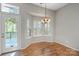 Bright dining area featuring hardwood floors, a bay window, door to deck, and chandelier at 5311 Courtfield Dr, Indian Trail, NC 28079