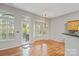 Open dining area with hardwood floors, a bay window, door to deck, and chandelier at 5311 Courtfield Dr, Indian Trail, NC 28079