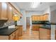 Bright kitchen featuring wooden cabinets, stone backsplash, modern appliances, and hardwood flooring at 5311 Courtfield Dr, Indian Trail, NC 28079