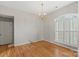 Living room featuring hardwood floors, natural light, chandelier, and an arched window at 5311 Courtfield Dr, Indian Trail, NC 28079