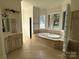 A relaxing bathroom with a large tub, tiled floors, and a vanity with cabinets at 5517 Mountain Point Ln, Charlotte, NC 28216
