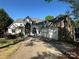 A stunning two-story home with stone and white exterior, features a three-car garage and arched entry at 5517 Mountain Point Ln, Charlotte, NC 28216