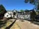 A stunning two-story home with stone and white exterior, features a three-car garage and arched entry at 5517 Mountain Point Ln, Charlotte, NC 28216