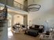 Bright living room with wood floors, high ceilings, decorative chandelier and ornate iron railing at 5517 Mountain Point Ln, Charlotte, NC 28216