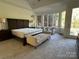 Bright main bedroom featuring large windows, seating area, and dark wood furniture at 5517 Mountain Point Ln, Charlotte, NC 28216