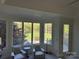 A bright main bedroom seating area with large windows overlooking the green backyard and pool at 5517 Mountain Point Ln, Charlotte, NC 28216