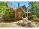 Beautiful backyard view of a two-story brick house with a patio and lush landscaping at 6009 Glen Manor Dr, Charlotte, NC 28269