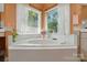 Bathroom featuring a garden tub with tile surround and large windows providing natural light at 6009 Glen Manor Dr, Charlotte, NC 28269
