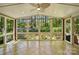 Bright sunroom featuring tile flooring, large windows with views of the backyard, and ceiling fan at 6009 Glen Manor Dr, Charlotte, NC 28269