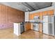 Stylish kitchen featuring stainless steel appliances, wooden cabinets, and an adjacent living space at 626 N Graham St # 405, Charlotte, NC 28202