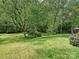 Expansive backyard with mature trees and manicured lawn creating a serene outdoor space at 6420 Saint John Ln, Charlotte, NC 28210