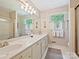 Bright bathroom featuring double sinks, cabinets, marble countertops, shower and a bright window with natural light at 6420 Saint John Ln, Charlotte, NC 28210