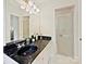 Bright bathroom featuring dark marble countertops, cabinets and a shower with natural light at 6420 Saint John Ln, Charlotte, NC 28210