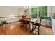 Traditional dining room featuring hardwood floors, wood table with chairs, and bright natural light from a large window at 6420 Saint John Ln, Charlotte, NC 28210