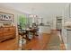 Bright kitchen with white cabinets, a wooden table, and views of the green outdoors at 6420 Saint John Ln, Charlotte, NC 28210