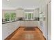 Bright kitchen featuring white cabinets, black countertops, and hardwood flooring at 6420 Saint John Ln, Charlotte, NC 28210