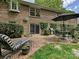 Brick patio featuring outdoor seating, a dining area, mature landscaping, and a grill at 6420 Saint John Ln, Charlotte, NC 28210