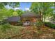 Rear exterior view of a brick home with a spacious backyard and patio at 6634 Rocky Falls Rd, Charlotte, NC 28211