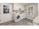 Well-organized laundry room with modern appliances, sink, and built-in storage cabinets at 6634 Rocky Falls Rd, Charlotte, NC 28211