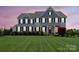 Elegant two-story home with a well-manicured lawn and trimmed hedges, providing an inviting curb appeal at 708 Brookmeade Dr, Waxhaw, NC 28173