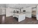 Spacious kitchen with white cabinets, a large island, stainless steel appliances, and dark hardwood floors at 708 Brookmeade Dr, Waxhaw, NC 28173