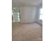 Open-concept living room with plush carpet and plenty of natural light from a nearby window at 7113 Sycamore Grove Ct, Charlotte, NC 28227