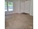 Spacious living room featuring plush carpet and large windows that offer plenty of natural light at 7113 Sycamore Grove Ct, Charlotte, NC 28227