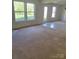 Bright living room with plush carpet and direct access to the backyard through a sliding glass door at 7113 Sycamore Grove Ct, Charlotte, NC 28227