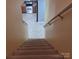 Carpeted stairs leading to an upper level with a view of the kitchen at 7113 Sycamore Grove Ct, Charlotte, NC 28227