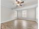 A bright bedroom with a ceiling fan, two windows, neutral walls, and vinyl plank flooring at 721 Broad St, Kannapolis, NC 28081