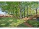 Lush green backyard with mature trees, perfect for outdoor activities and relaxation at 7220 Spring Morning Ln, Charlotte, NC 28227