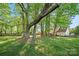 Spacious backyard with mature trees and partial view of the house, ideal for outdoor enjoyment at 7220 Spring Morning Ln, Charlotte, NC 28227