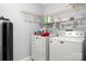 Well-organized laundry room with white washer, dryer, water heater, water filter, and shelving at 7220 Spring Morning Ln, Charlotte, NC 28227