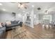 Cozy living room showcases a comfortable sofa and glass coffee table, open to dining area and breakfast bar at 7220 Spring Morning Ln, Charlotte, NC 28227